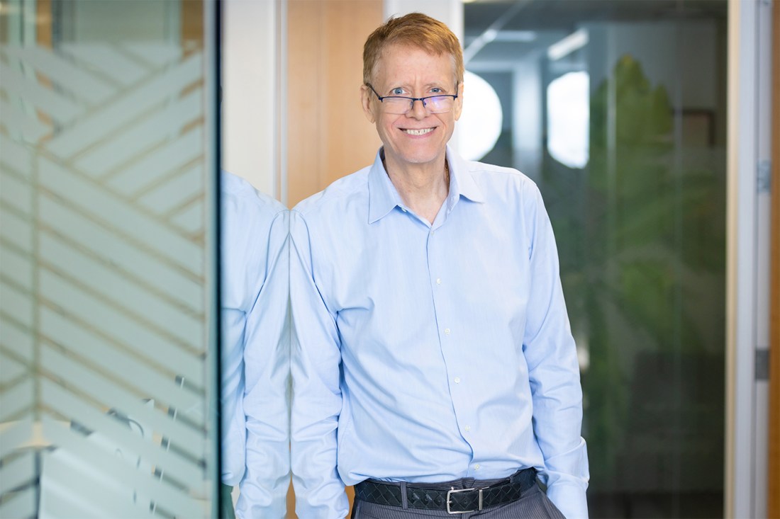 Portrait of David de Hilster wearing a blue button down shirt and glasses.