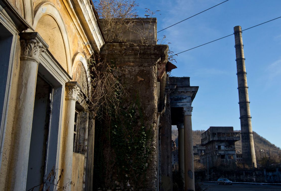 A car drives past an abandoned power plant in the town of Tkvarcheli, in Abkhazia, a Russia-backed breakaway Georgian region, on December 26, 2013.