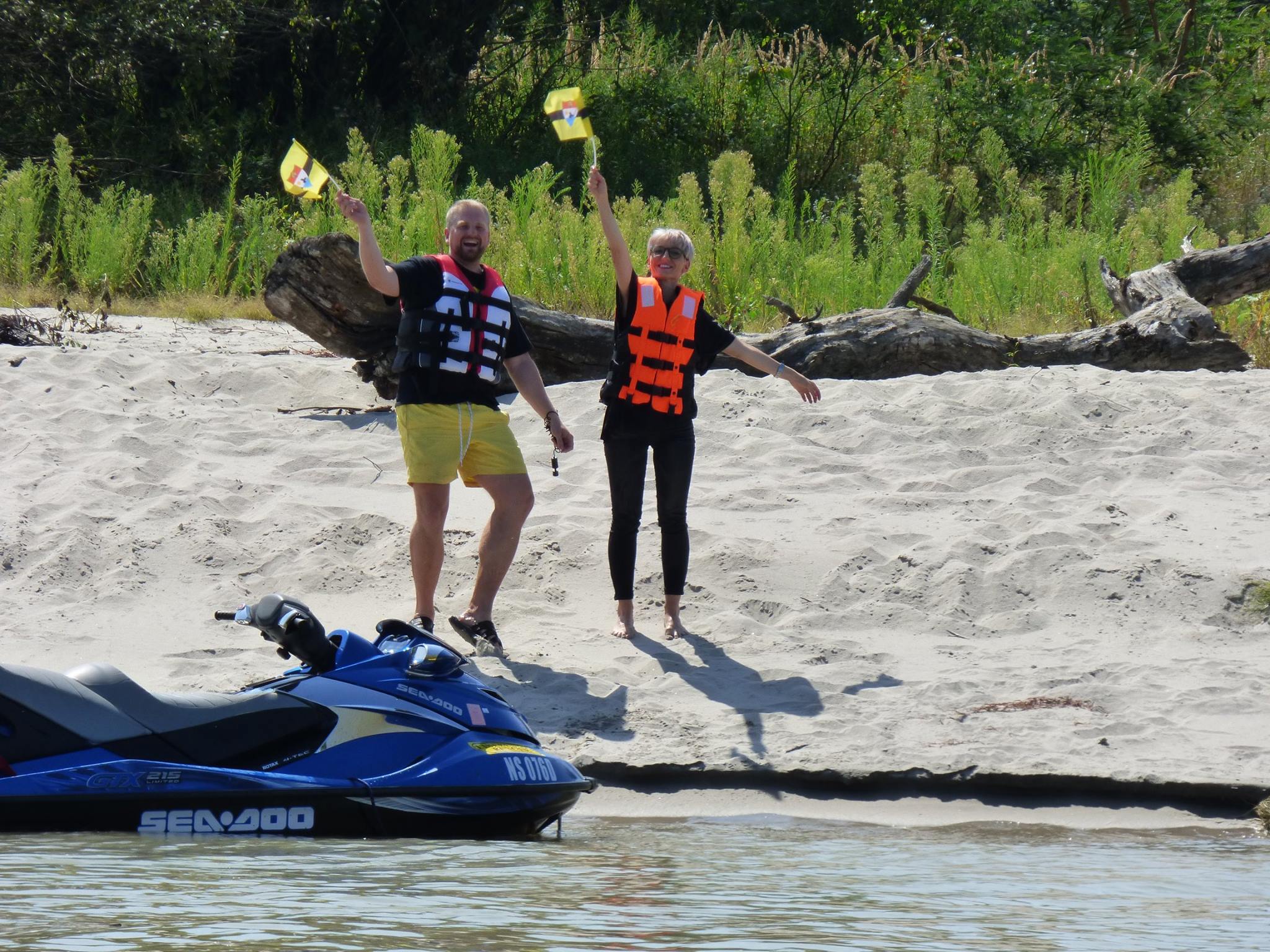 Jedlička (left) makes landfall on the presidential jet ski, holding the Liberland flag.