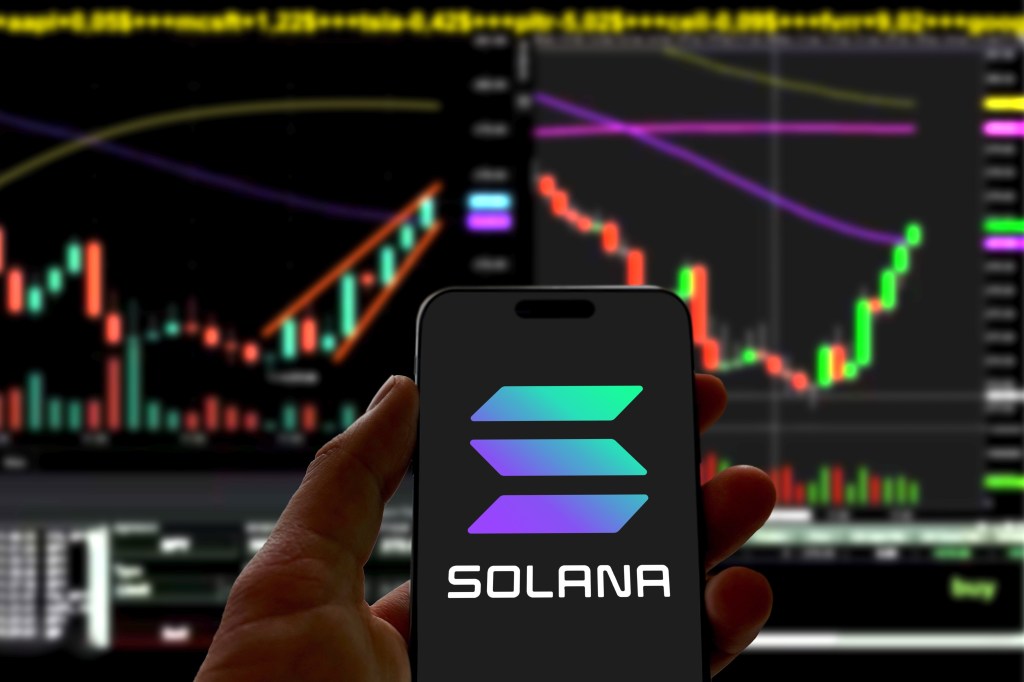 The Solana logo displayed on a smartphone with cryptocurrency charts in the background.