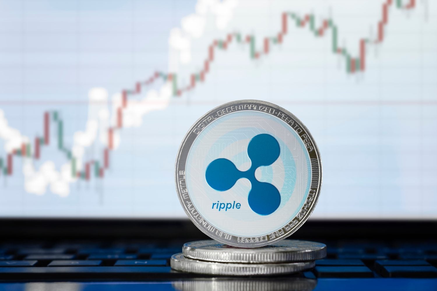 RIPPLE (XRP) cryptocurrency; physical concept ripple coin on the background of the chart